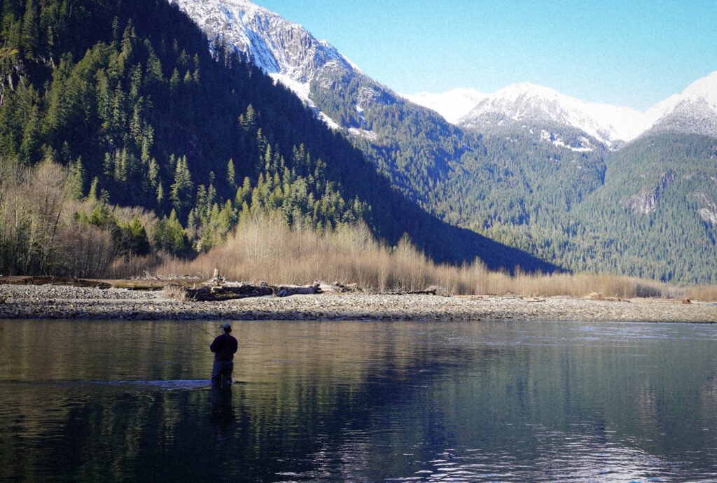Man wading in B.C. river fishing for salmon