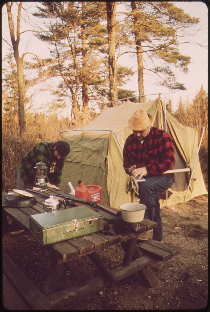 Two men outside of their tent at their hunting camp