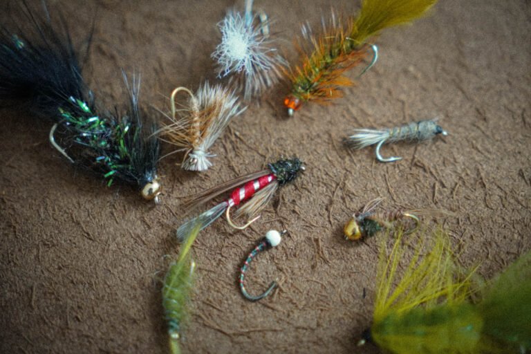 The 10 best flies for bc trout fishing laid out on a leather mat